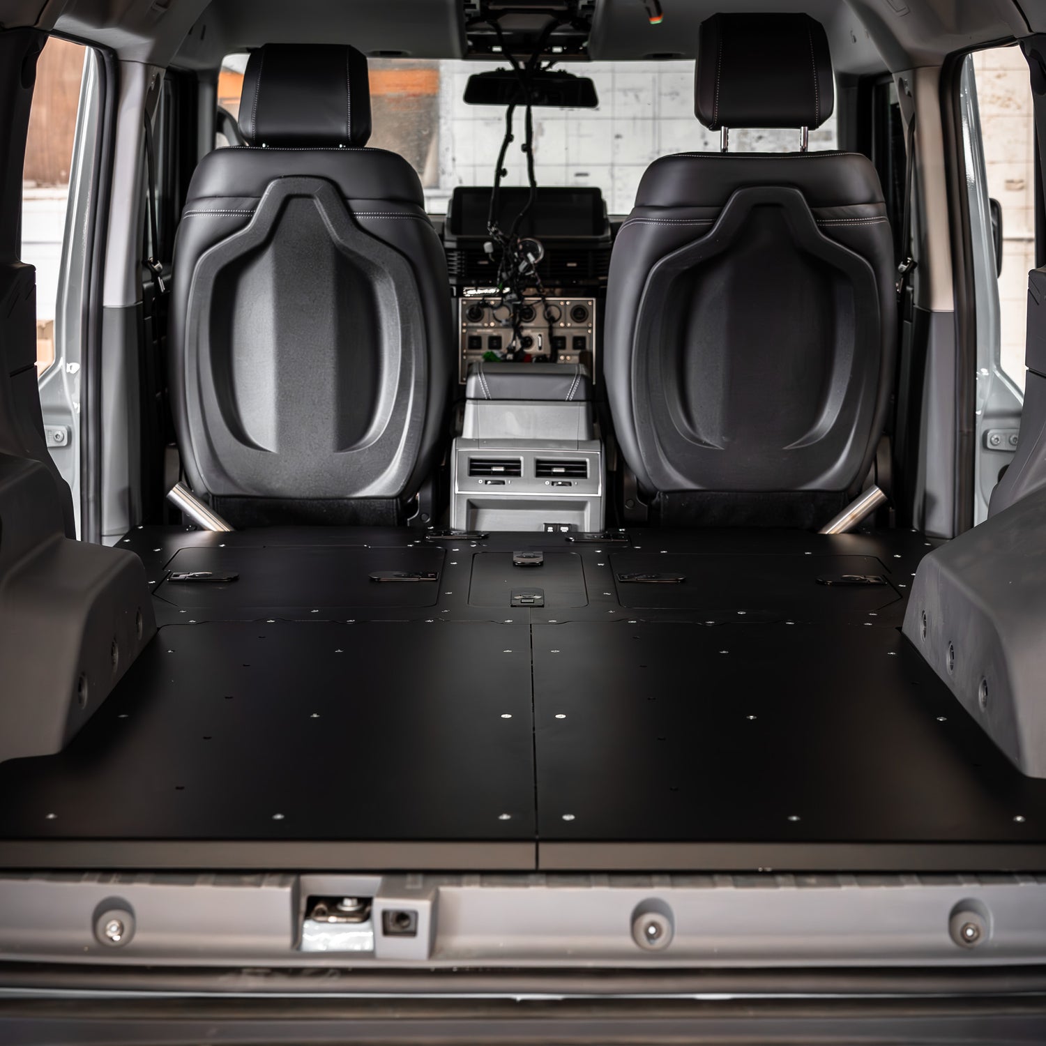 Buzz Overland Buzz Base for INEOS Grenadier, a 36kg 5052 aluminium deck replacing 56kg factory seats, with access hatches for stealth overlanding and roof conversions.