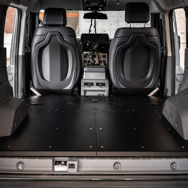 Buzz Overland Buzz Base for INEOS Grenadier, a 36kg 5052 aluminium deck replacing 56kg factory seats, with access hatches for stealth overlanding and roof conversions.
