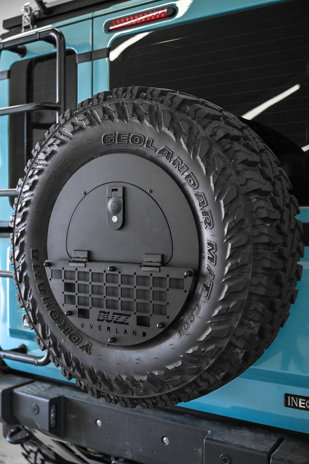 Black molle panel on Buzz Overland Spare Wheel Storage Cubby for INEOS Grenadier, offering versatile accessory mounting for overlanding and off-road customization