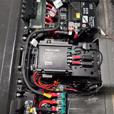 Alpha50 R charger mount under the INEOS Grenadier rear seat, between starter and auxiliary battery